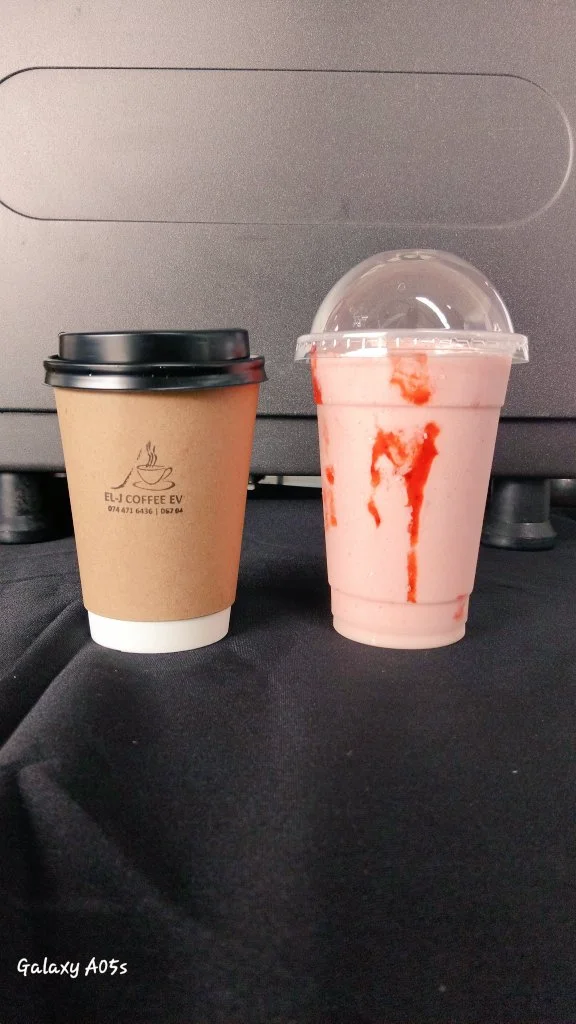 EL-J branded takeaway cup next to a strawberry frappé