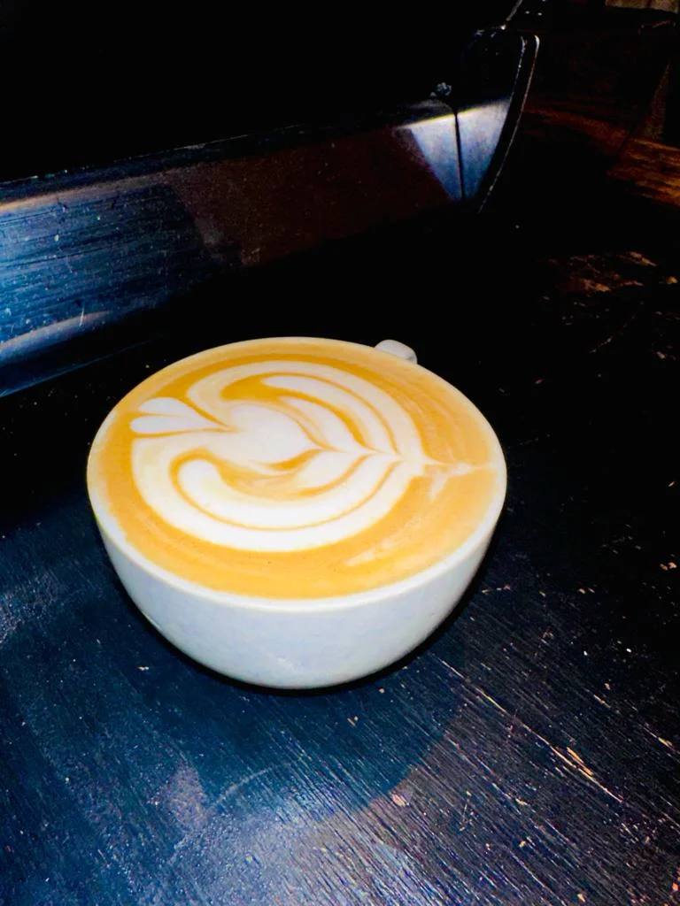 Dark moody latte on a polished wooden surface