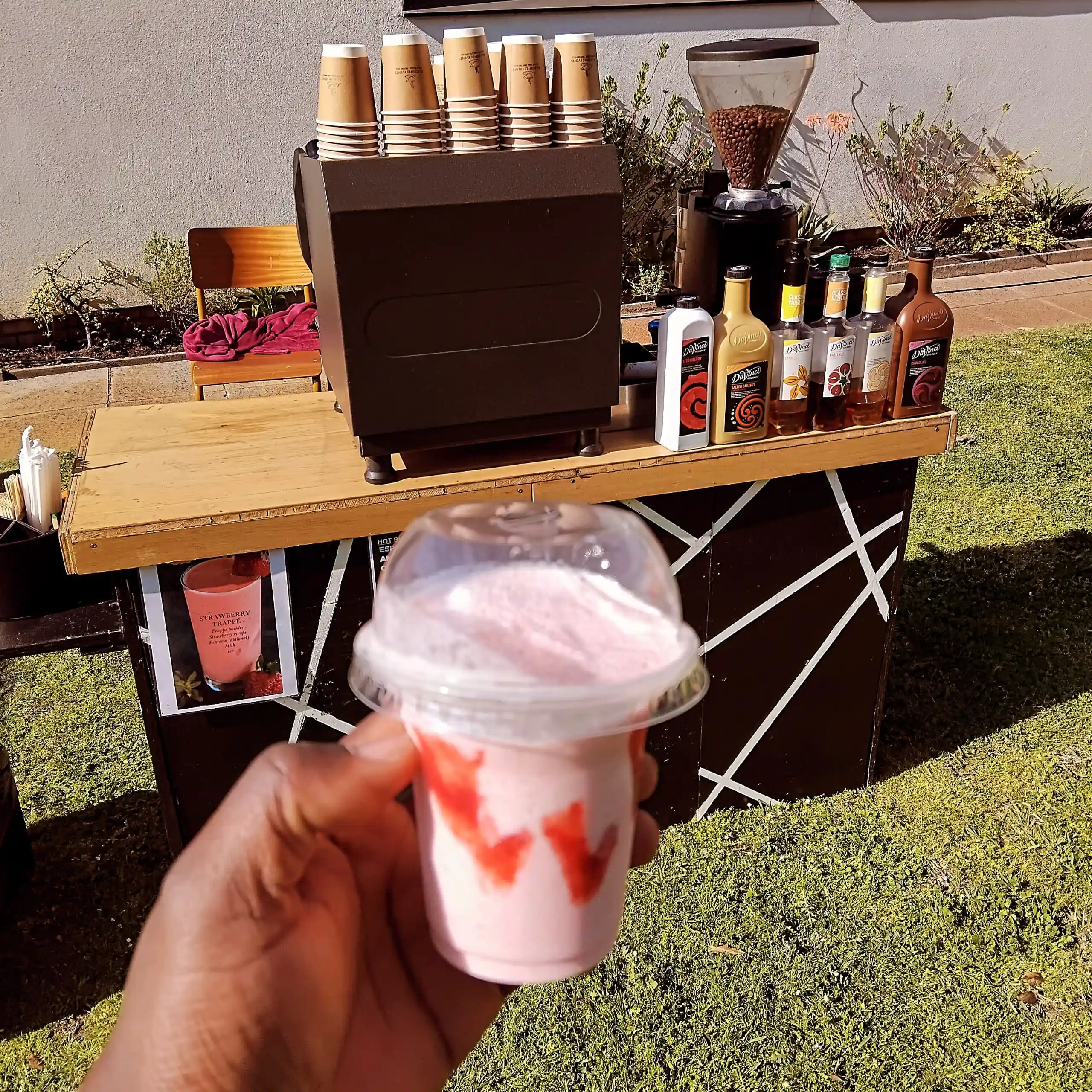 Strawberry frappé in hand with EL-J mobile setup in background