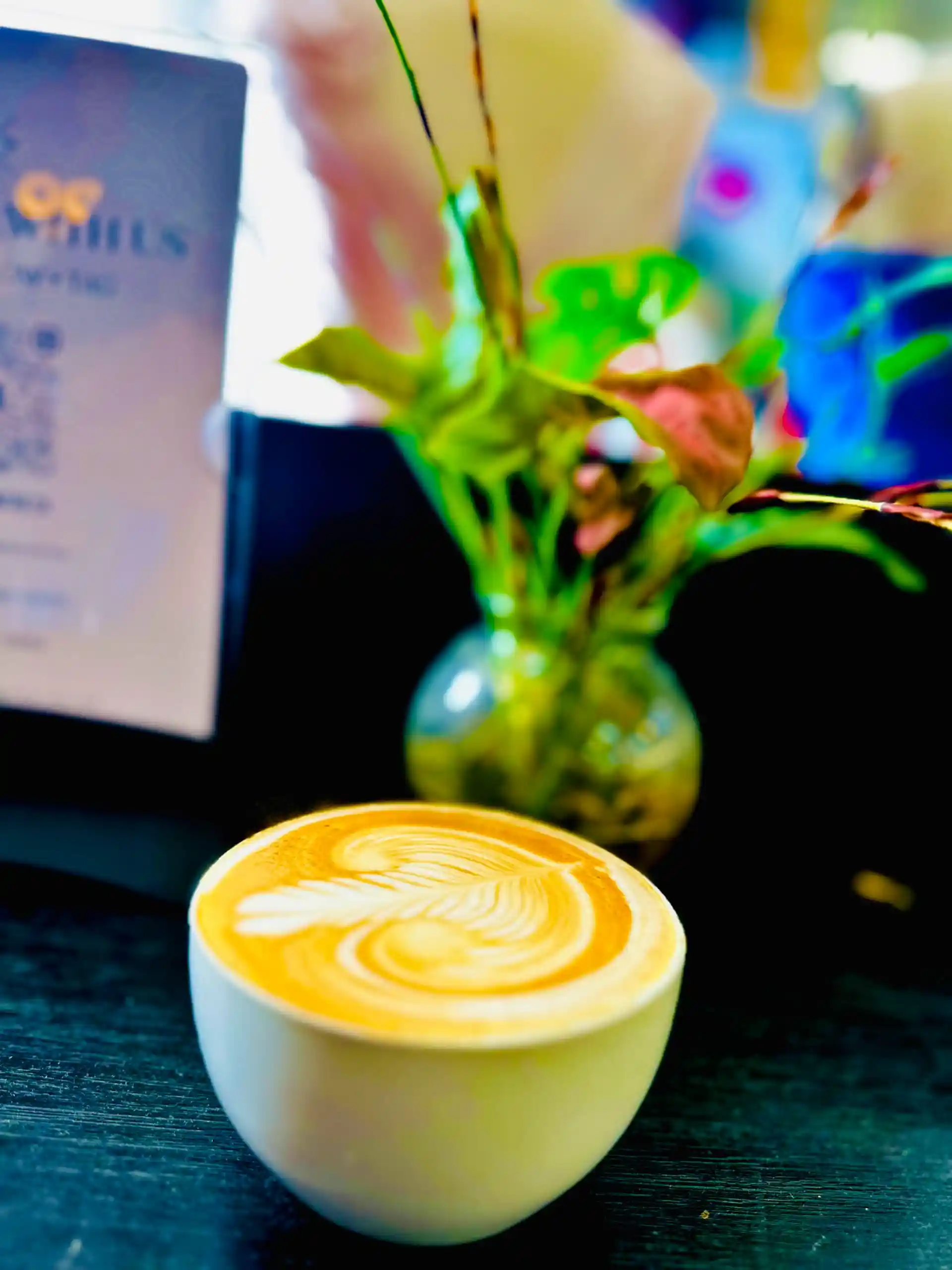 Freshly poured latte at a market with branded cups visible