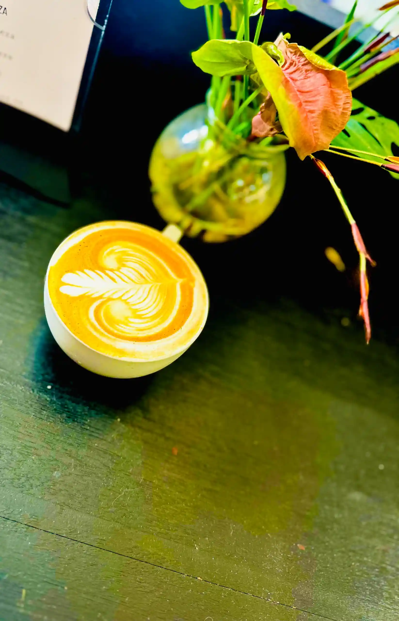 Elevated overhead latte art with colourful flower arrangement