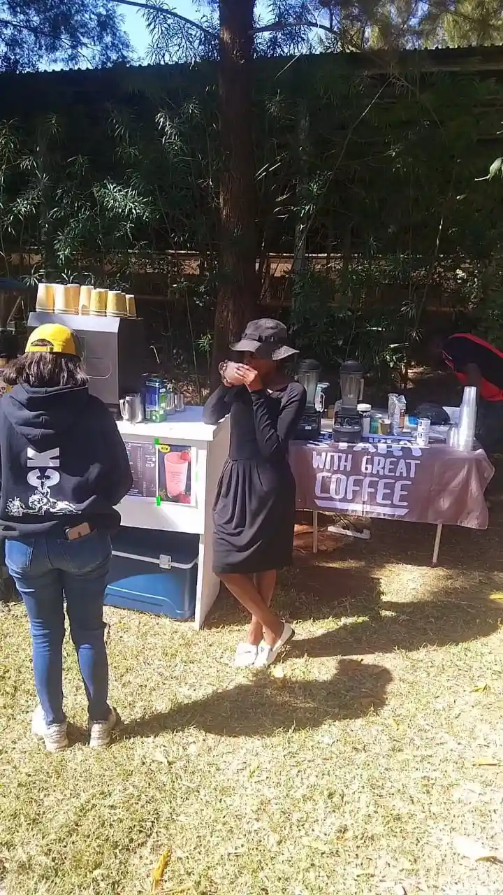 EL-J Coffee latte in a branded cup on a grass field